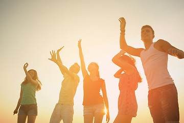 Image showing smiling friends dancing on summer beach