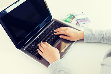 Image showing close up of woman hands with laptop and money