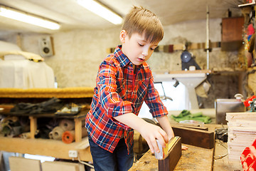 Image showing happy little boy with plank and ruler at workshop