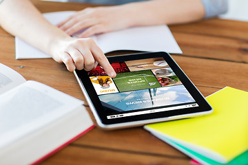 Image showing close up of student with tablet pc and notebook