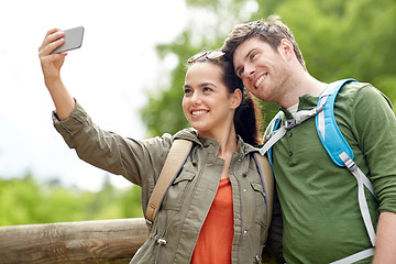 Image showing couple with backpacks taking selfie by smartphone