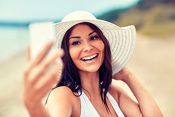 Image showing smiling young woman taking selfie with smartphone