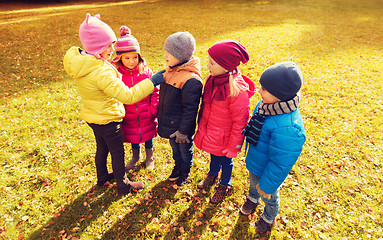 Image showing kids in autumn park counting and choosing leader