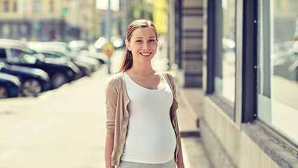 Image showing happy smiling pregnant woman at city street