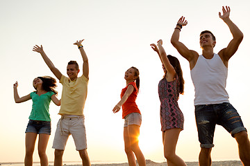 Image showing smiling friends dancing on summer beach