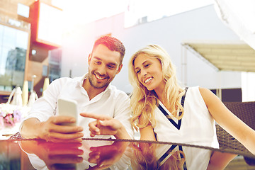 Image showing happy couple with smatphone at restaurant terrace