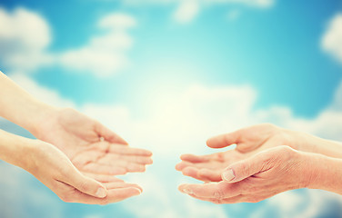 Image showing close up of senior and young woman hands