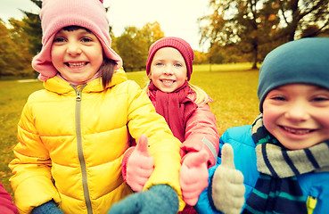 Image showing happy children showing thumbs up in autumn park