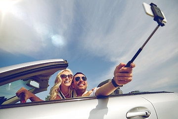 Image showing happy couple in car taking selfie with smartphone