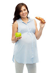 Image showing happy pregnant woman with apple and croissant