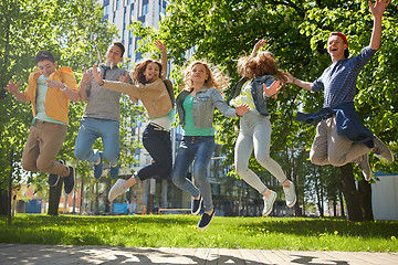 Image showing happy teenage students or friends jumping outdoors