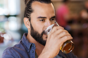 Image showing happy man drinking beer at bar or pub