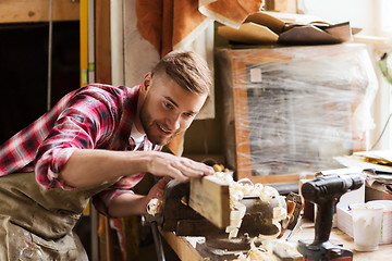 Image showing carpenter working with wood plank at workshop