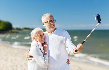 Image showing happy senior couple hugging on summer beach