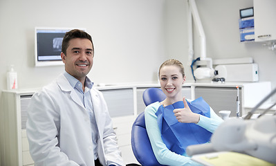 Image showing happy male dentist with woman patient at clinic