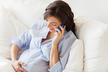 Image showing happy pregnant woman calling on smartphone at home