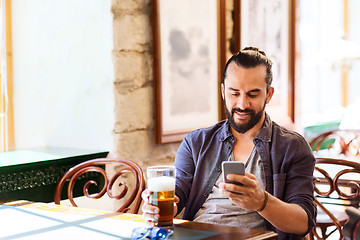 Image showing man with smartphone drinking beer at bar or pub