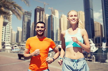 Image showing couple running over dubai city street background