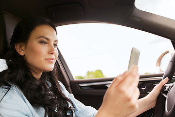 Image showing happy woman driving car with smarhphone