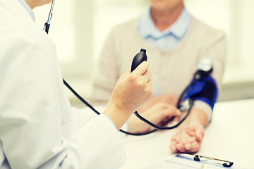 Image showing doctor with tonometer and senior woman at hospital