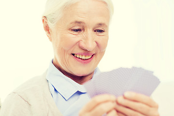 Image showing happy senior woman playing cards at home
