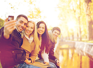 Image showing group of friends with photo camera in autumn park