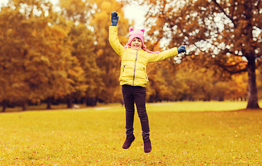 Image showing happy little girl jumping outdoors