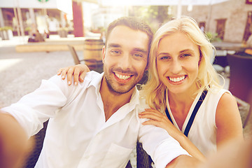 Image showing happy couple taking selfie at restaurant terrace