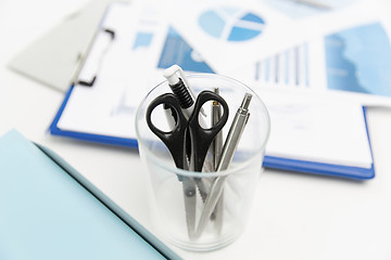 Image showing close up of cup with scissors and pens at office