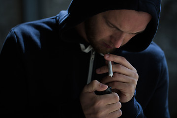 Image showing close up of addict lighting up marijuana joint