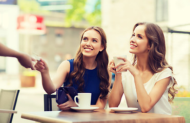 Image showing women with credit card paying for coffee at cafe