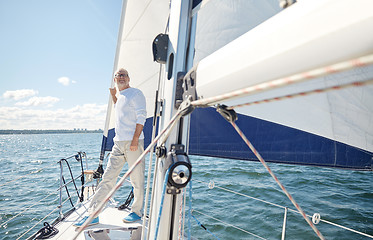 Image showing senior man on sail boat or yacht sailing in sea