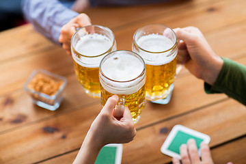 Image showing close up of hands with beer mugs at bar or pub