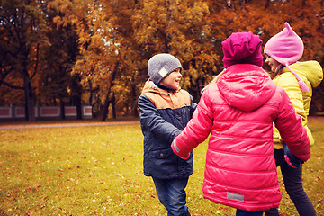 Image showing children holding hands and playing in autumn park