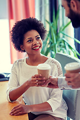 Image showing happy woman taking coffee from man in office