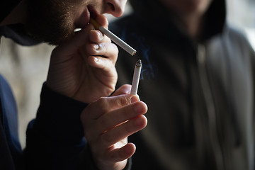 Image showing close up of young people smoking cigarette