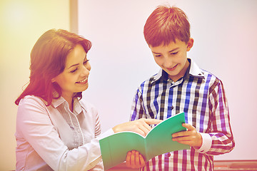 Image showing school boy with notebook and teacher in classroom