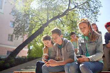 Image showing group of teenage friends with smartphones outdoors