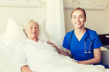 Image showing doctor or nurse visiting senior woman at hospital