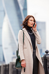 Image showing woman in a bright coat talking on the phone