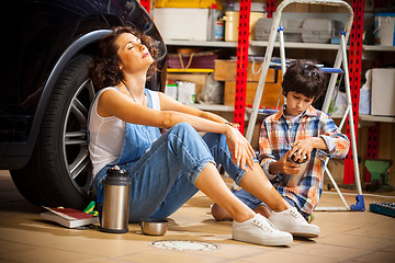 Image showing resting mechanic woman and boy with thermos