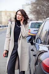 Image showing fashion. beautiful woman in a bright coat talking on the mobile