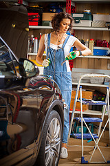Image showing mechanic woman working on a car in an auto repair shop