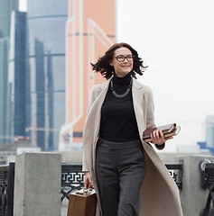 Image showing smiling middle aged brunette in the business district of the cit