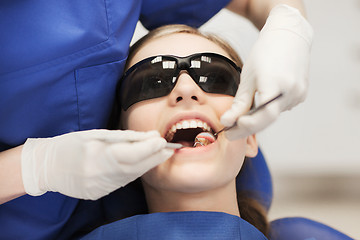 Image showing female dentist checking patient girl teeth