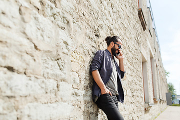 Image showing smiling man with smartphone calling on city street