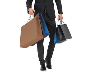 Image showing close up of man in suit with shopping bags