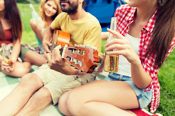 Image showing happy friends with drinks and guitar at camping