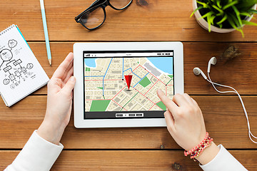 Image showing close up of woman with tablet pc on wooden table