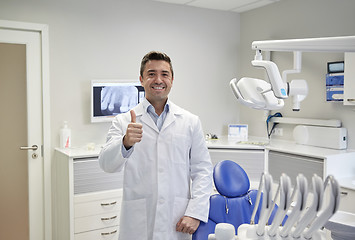 Image showing happy male dentist showing thumbs up at clinic